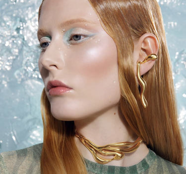 耳に巻きつくゴールドの液体ピアス